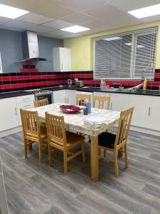 a kitchen with a table with chairs and a tableasteryasteryasteryasteryasteryastery at Private Room 2 Near Southmead Hospital, Bristol in Bristol