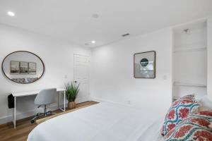 a white bedroom with a bed and a desk at Sailors Rest @ Sailboat Bend in Fort Lauderdale
