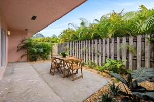 un patio con mesa y sillas frente a una valla en Sailors Rest @ Sailboat Bend, en Fort Lauderdale