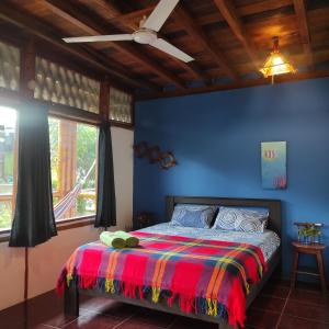 1 dormitorio con 1 cama con una manta colorida en Montañita Cabañas, en Montañita