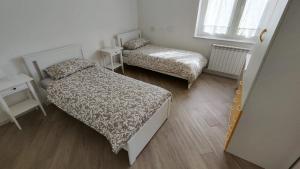 - une petite chambre avec 2 lits et une fenêtre dans l'établissement Casa vacanza SERENDIPITY HOME, à Trieste