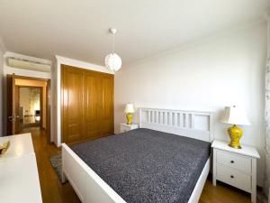 um quarto com uma cama grande e duas mesas de cabeceira em apartamento grande da Gama em Lisboa