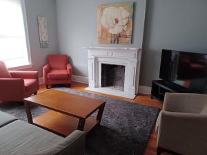 a living room with a fireplace and a tv at Historic First Floor Unit in STL - 5 Bedrooms in Soulard