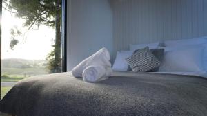 een witte handdoek bovenop een bed bij The Kauri Retreat 1 in Waitoki