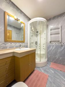 uma casa de banho com um lavatório e um chuveiro em apartamento grande da Gama em Lisboa