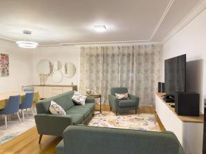 uma sala de estar com um sofá e duas cadeiras em apartamento grande da Gama em Lisboa