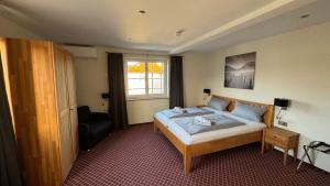 ein Schlafzimmer mit einem Bett, einem Stuhl und einem Fenster in der Unterkunft Hotel Leitner in Kaufbeuren