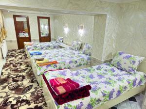 - 2 lits dans une chambre de couleur violette et blanche dans l'établissement HOTEL-129, à Samarcande