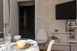 a dining room with a table and a tv at Photo Art apartment in Burgas City
