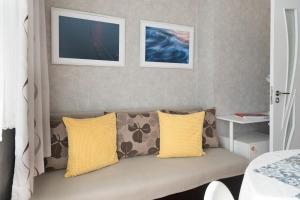 a couch with yellow pillows in a bedroom at Photo Art apartment in Burgas City