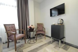 a living room with two chairs and a television at Güler Palas İstanbul Hotel in Istanbul