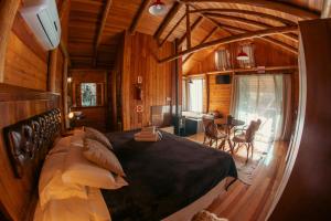 a bedroom with a large bed in a cabin at Hospedaria Refugio do Invernador in Urubici