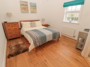 シーハウシズにあるLittle Ternのベッドと木の床のある寝室