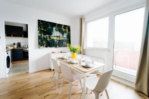 a white dining room with a white table and chairs at Jenapartments for6 Boxspring & Smart TV & Waschmaschine in Jena