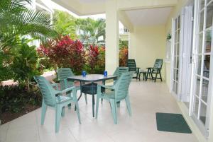 a patio with a table and chairs and plants at 26 Margate Gardens in Bridgetown