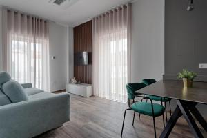 ein Wohnzimmer mit einem Sofa, einem Tisch und Stühlen in der Unterkunft Palazzo Cajeta in Gaeta