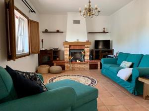 een woonkamer met een blauwe bank en een open haard bij Quinta Kaleidoscope in Vendas Novas