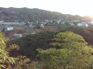 Blick auf eine Stadt von einem Hügel mit Bäumen in der Unterkunft Djabraba's Eco-Lodge in Vila Nova Sintra