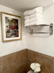 a bathroom with a pile of towels on a shelf at Stylish Evergreen Apartment By Newark Airport in Newark
