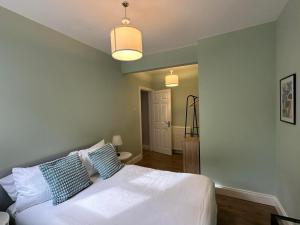 a bedroom with a white bed with blue pillows at Belle View Apartment #4 in Newcastle