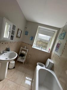een badkamer met een wastafel, een bad en een toilet bij Belle View Apartment #4 in Newcastle