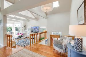 a living room with white walls and a vaulted ceiling at Coastal Cape May Getaway - Steps to Beach! in Cape May