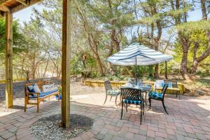 a table and chairs with an umbrella on a patio at Coastal Cape May Getaway - Steps to Beach! in Cape May