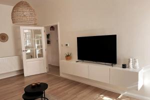 un salon avec une télévision à écran plat sur une armoire blanche dans l'établissement Prachtige woning centrum Hasselt, à Hasselt