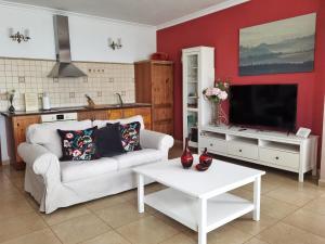 a living room with a white couch and a tv at Casa Lagarto in El Paso