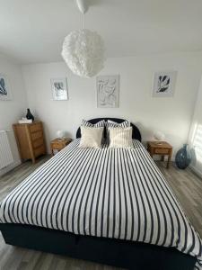 ein Schlafzimmer mit einem schwarz-weiß gestreiften Bett in der Unterkunft Appartement Plein Centre in Saint-Brevin-les-Pins