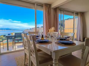 - une salle à manger avec une table et une vue sur l'océan dans l'établissement Spacieux 3P Mer & Montagne - Les Clés de l Estérel, à Théoule-sur-Mer