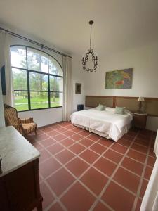 Habitación grande con cama y ventana grande. en La Justina - Casa de Campo en San Lorenzo en San Lorenzo