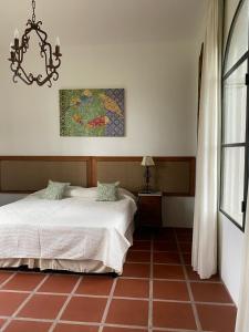 1 dormitorio con cama y lámpara de araña en La Justina - Casa de Campo en San Lorenzo en San Lorenzo