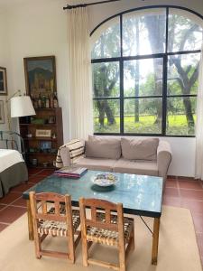 a living room with a couch and a table and two chairs at La Justina - Casa de Campo en San Lorenzo in San Lorenzo