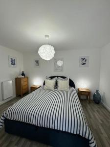 Schlafzimmer mit einem Bett mit einer schwarz-weißen gestreiften Bettdecke in der Unterkunft Appartement Plein Centre in Saint-Brevin-les-Pins