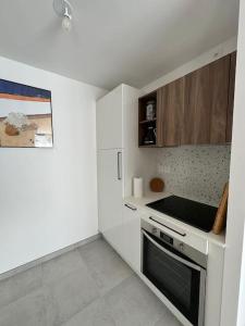 una piccola cucina bianca con piano cottura e forno di Appartement Plein Centre a Saint-Brévin-les-Pins