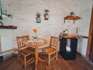 uma mesa e duas cadeiras numa sala com um balcão em Residencial Vilas Boas MV em Monte Verde
