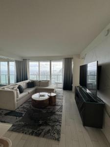 sala de estar con sofá y TV en Nautica - Ocean View & Rooftop Pools! by Newman Hospitality, en Fort Lauderdale