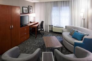 a hotel room with a desk and a living room at Courtyard by Marriott Santa Clarita Valencia in Valencia