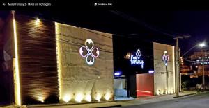 a building with signs on the side of it at night at Motel Fantasy 2 (Adult Only) in Contagem
