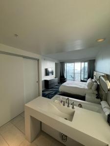 Habitación de hotel con cama y lavabo en Nautica - Ocean View & Rooftop Pools! by Newman Hospitality, en Fort Lauderdale