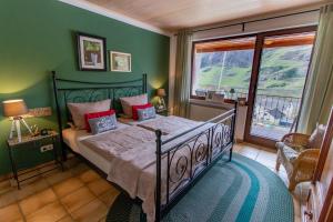 a bedroom with a bed with green walls and a window at Bed & Breakfast Sandra Müller in Burg an der Mosel
