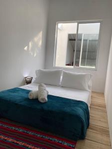 Un dormitorio con una cama grande con un osito de peluche. en AFRA Reserva Natural, en Santa Marta