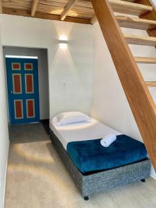 1 dormitorio con 1 cama en una habitación con escalera en AFRA Reserva Natural, en Santa Marta