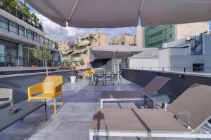a rooftop patio with chairs and tables and umbrellas at athensotel in Athens