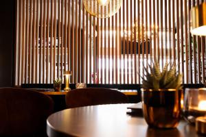 een eetkamer met een tafel en stoelen en kroonluchters bij Hotel XL in Zandvoort