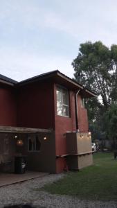 una casa roja con ventana y patio en Wood Side Hostel en Mar del Plata
