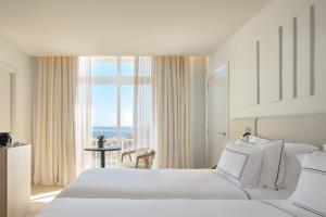 a bedroom with a large bed and a large window at Meliá Lloret de Mar in Lloret de Mar