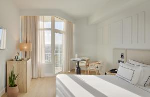 a bedroom with a bed and a table and a window at Meliá Lloret de Mar in Lloret de Mar