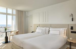 a large white bed in a room with a window at Meliá Lloret de Mar in Lloret de Mar